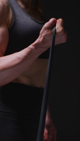 Vertical-Video-Close-Up-Shot-Of-Mature-Woman-Wearing-Gym-Fitness-Clothing-Exercising-With-Resistance-Band-1